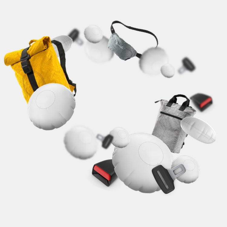 Vor weißem Hintergrund fliegen Airbagkissen; Anschnaller und Gurtschlösser, zwei Rucksäcke in Gelb und in Grau und eine Bauchtasche in der Farbe Eukalyptus.